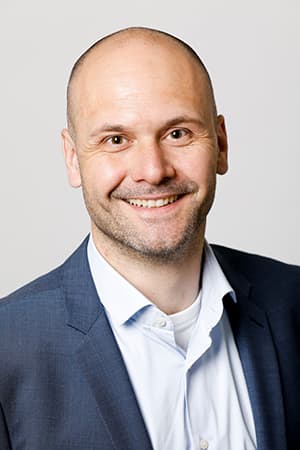 Kandidat Online Assessment Profilbild: Ein sympathischer jüngerer Herr mit Glatze blickt lächelnd in die Kamera: Pascal Löpfe Brügger, Kandidat Online Assessment