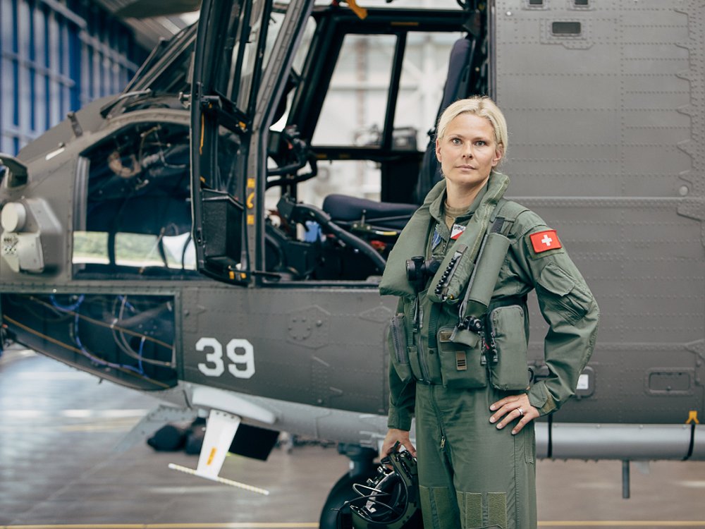 Eine junge blonde Frau. Sie trägt Politen-Montur. Sie steht vor einem Kleinflugzeug. Symbolbild für Assessment-Tools.